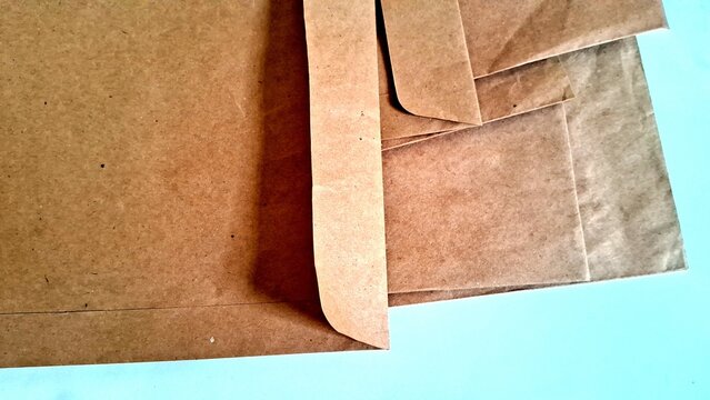 Brown paper envelopes stacked neatly on a clean white desk surface