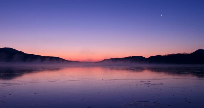 凍る屈斜路湖の気嵐と夜明けの月