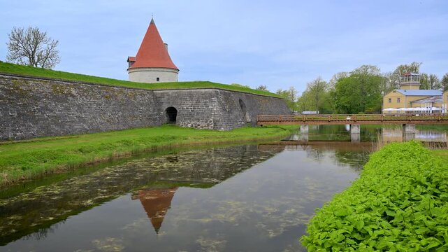 Medieval Kuressaare castle tower with reflection in the moat