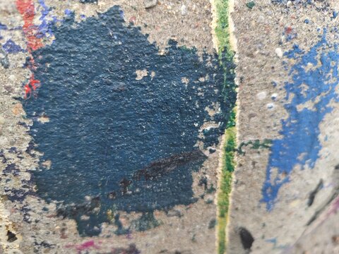 Teal and blue paint patches on textured concrete, abstract urban background