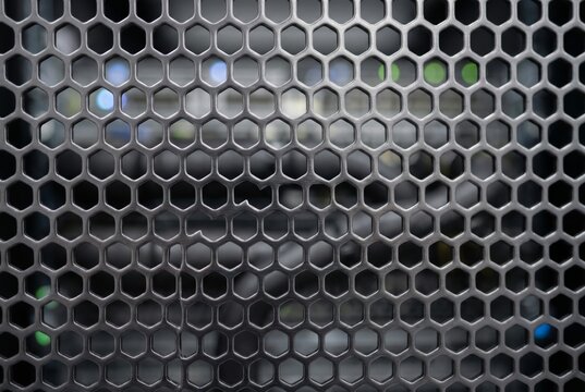 Perforated metal server rack close-up showcasing modern data center infrastructure with cooling system details