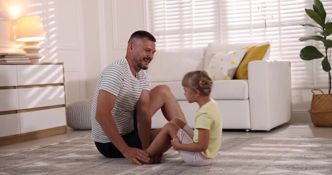 Father and daughter doing morning exercise together at home