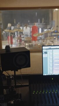 Live room view. Waveform tracks and distant musicians recording live