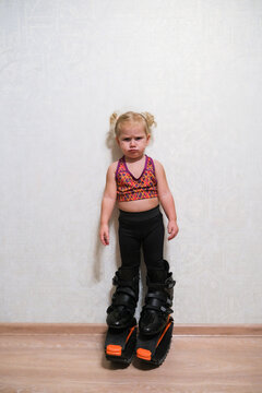 The child is standing in a sports uniform and in Stylish kangoo shoes