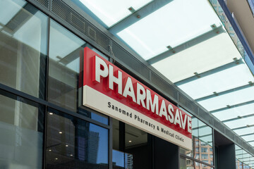 Fototapeta premium Toronto, ON, Canada - August 21, 2026: The sign displays the storefront for Pharmasave (Sanomed Pharmacy and Medical Clinic) on Bay Street, Toronto, ON, Canada. 