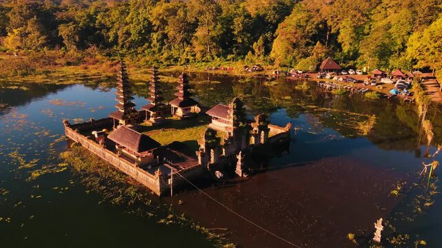 Scenic view of Gubug Temple at misty Lake Tamblingan surrounded by lush rainforest in Bedugul, Bali, Indonesia