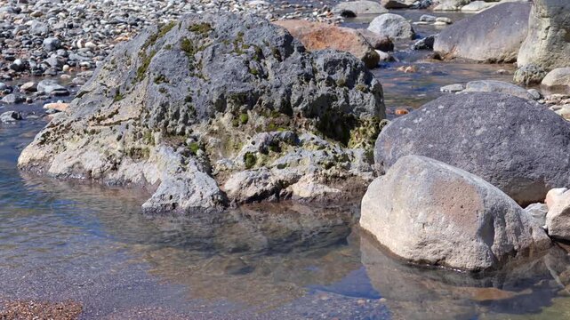 石の合間を水が流れる川の風景。