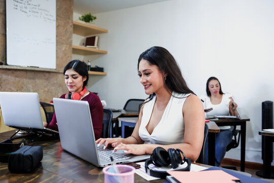 group of latina women using laptop at office in Mexico Latin America. Hispanic teamwork of females at workplace 