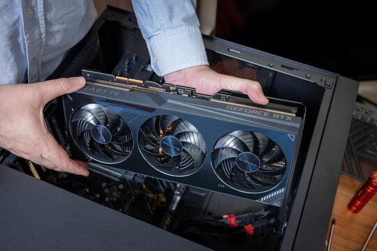 A technician installs an expensive and powerful GIGABYTE graphics card into a PC. Building or upgrading a high-end gaming PC or graphics workstation. Pavlodar, Kazakhstan - January 7, 2026