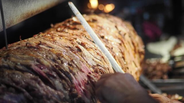 Chef Slicing Traditional Doner Kebab Meat on Vertical Rotisserie