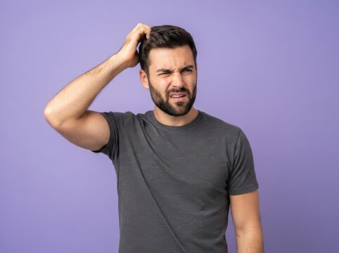 Confused man scratching his head with a skeptical and puzzled expression, isolated against a solid purple studio background