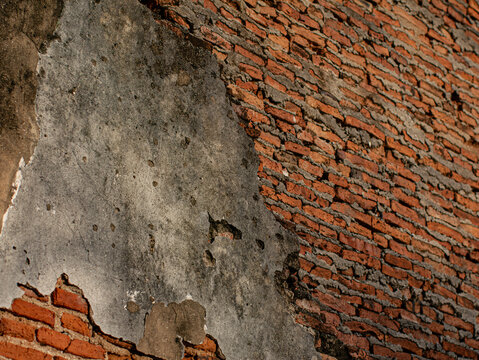 Cracked Plaster Wall Exposing Red Brick Underneath, Weathered Ruin Texture Background