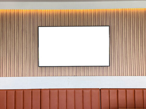 TV blank screen mounted on a wall in a coffee shop or cafe. Bright modern interior. A large plasma TV in a restaurant