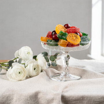 Colorful Sugared Jelly Candies on Glass Stand with White Roses