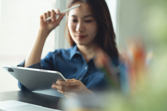 Asian business woman architect using digital tablet for creating interior design project in modern studio office. 