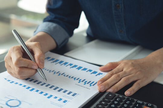 Business woman analyzing financial with corporate document and calculator on office desk, business planning and budget management