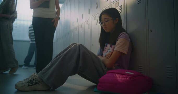 Compassionate Educator Approaches Quiet High School Girl Sitting on Floor near Locker and Begins Supportive Conversation. Importance of Attentive Teachers Creating Inclusive Learning Environment.