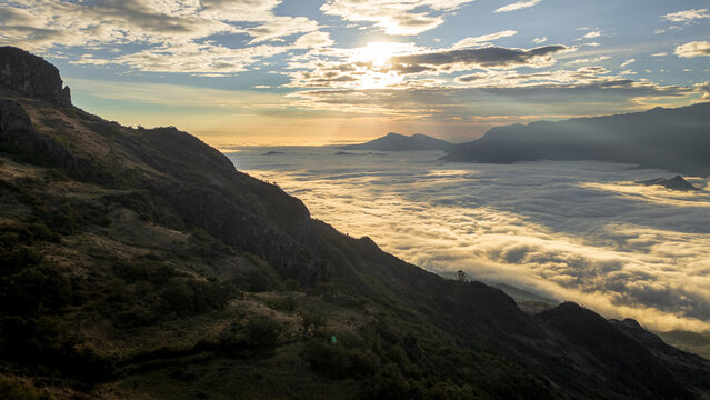 Andean sunset seen from Cerro Llipta in the district of Llama, Cajamarca, Peru. The setting sun illuminates a vast sea of ​​clouds covering the valleys surrounded by mountains in the distance