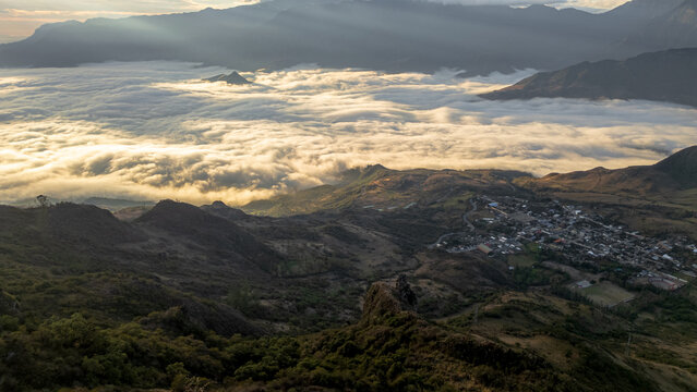 Andean sunset seen from Cerro Llipta in the district of Llama, Cajamarca, Peru. The setting sun illuminates a vast sea of ​​clouds covering the valleys surrounded by mountains in the distance