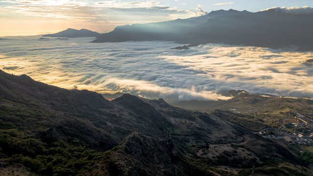 Andean sunset seen from Cerro Llipta in the district of Llama, Cajamarca, Peru. The setting sun illuminates a vast sea of ​​clouds covering the valleys surrounded by mountains in the distance