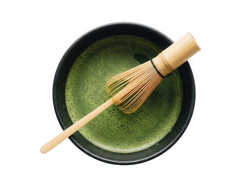 Taz&oacute;n cer&aacute;mico con t&eacute; verde matcha espumoso y batidor de bamb&uacute; chasen tradicional visto desde arriba aislado sobre fondo blanco.