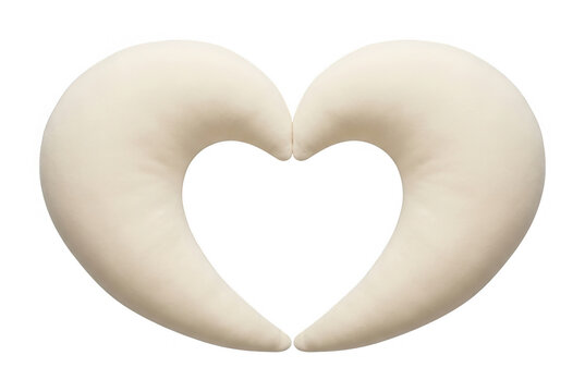 Dos cojines de lactancia de color crema dispuestos en forma de coraz&oacute;n sobre un fondo blanco aislado, s&iacute;mbolo de maternidad y amor maternal.