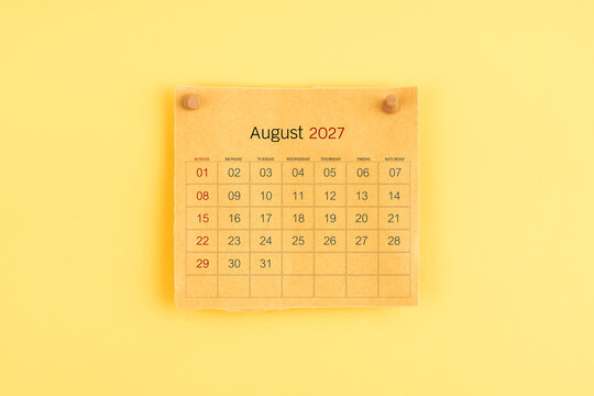 August 2027 brown calendar with wooden thumbtack on yellow background.