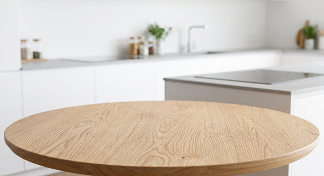 Empty round wooden table top in a modern bright white kitchen interior. Blurred background for product display mockup.