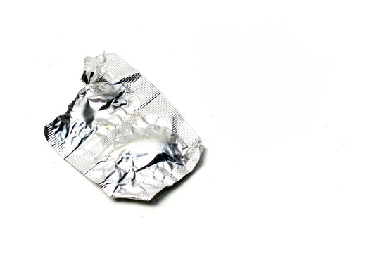 An empty foil blister pack torn open on a isolated white background.