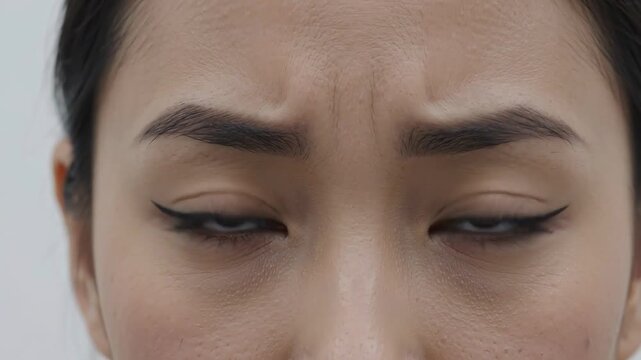Macro Close Up of Asian Woman Eyes and Furrowed Brow Expressing Concern Doubt and Anger