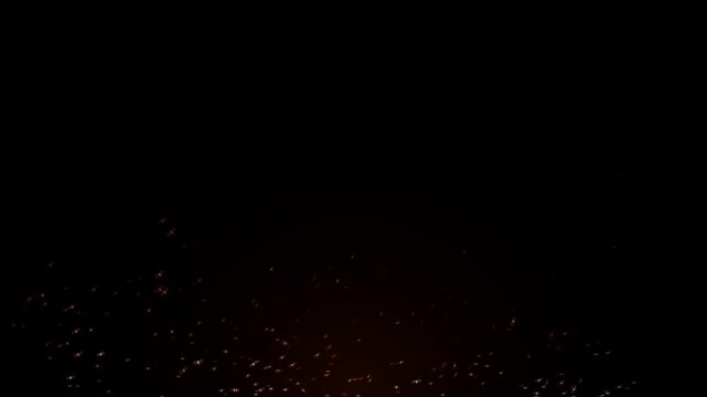 Glowing fire sparks floating in dark night background, cinematic burning embers overlay for special effects and motion