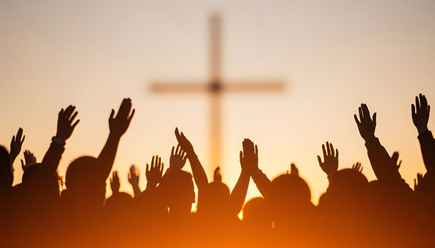 Silhouette of crowd raising hands in worship toward cross at sunset