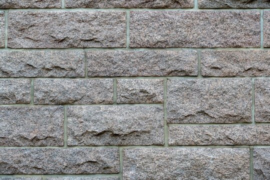 Detailaufnahme einer rustikalen Steinmauer aus behauenen Granitbl&ouml;cken mit feinen Fugen f&uuml;r Architektur, Bauwesen und solide Fassadengestaltung im Au&szlig;enbereich.