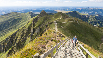 Fototapeta premium randonneur sur les escaliers du sommet du Puy de Sancy dans les Mont dore dans le Puy de Dôme en Auvergne, sommet volcanique de la Chaîne des Puys en France 