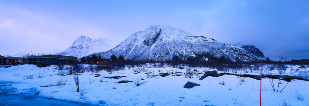 Stunning Wide Panorama of Massive Snow-Covered Arctic Mountains and Winter Landscape at Twilight (Blue Hour) in Norway, with Remote Cabins.