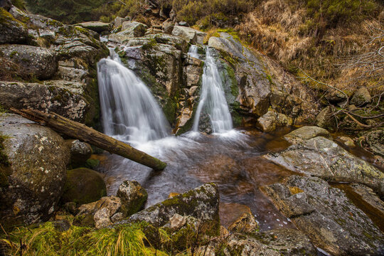 Bila Smeda Waterfall flowing in two streams between granite rocks in the Jizera Mountains near Smedava, Czech Republic.