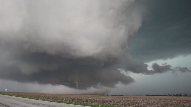 A huge rotating wall cloud with swirling dirt beneath it indicates this storm is ready to produce a tornado at any moment. Time lapse video.