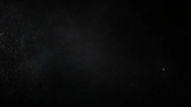 Dark background with scattered floating dust or smoke particles