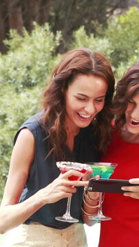 Two ladies taking selfies while drinking cocktails 4k