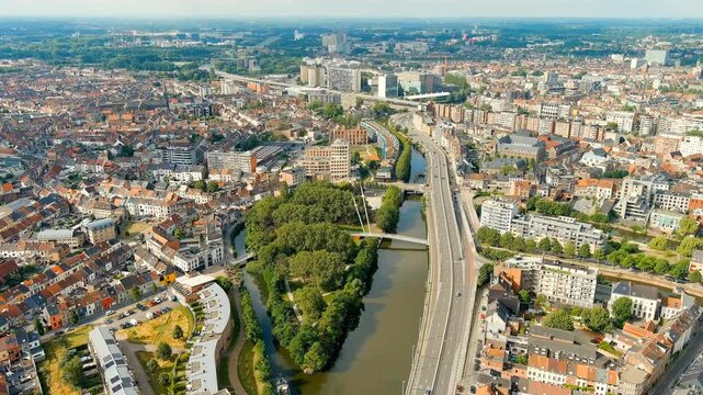 Ghent, Belgium. Keizerpark - City park. Esco (Scheldt) river embankment. Panorama of the city from the air. Cloudy weather, summer day. Drone footage