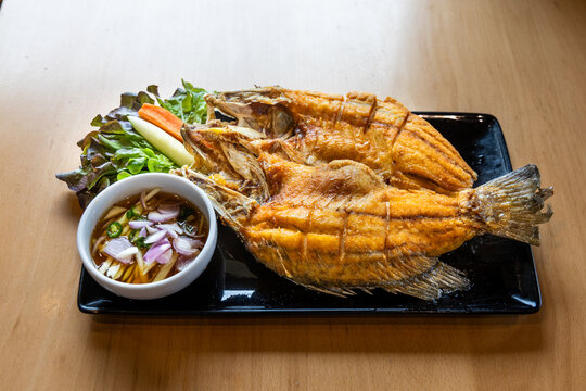 Thai style crispy butterfly fried fish served with garnish and dips. Known as butterfly because tilapia fish is halved resembles butterfly wings