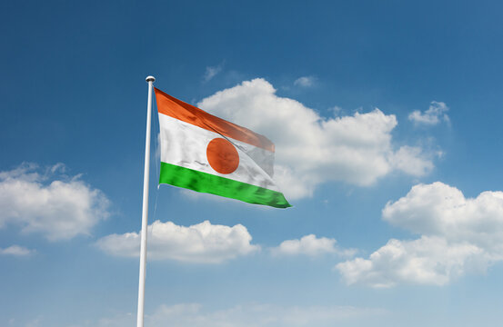 Niger flag waving in beautiful sky.