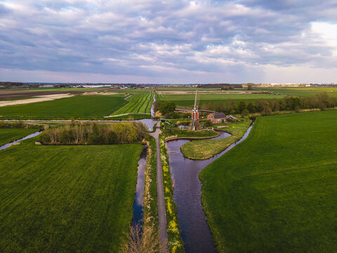 Traditional Dutch windmill among green polder fields