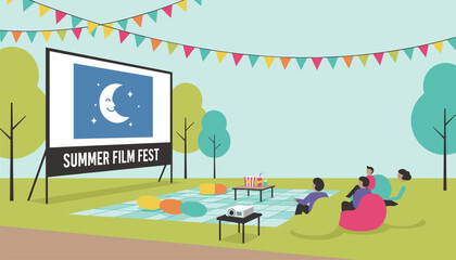 Fototapeta premium Cozy outdoor cinema event in a park with people sitting on bean bags watching a screen under the night sky.