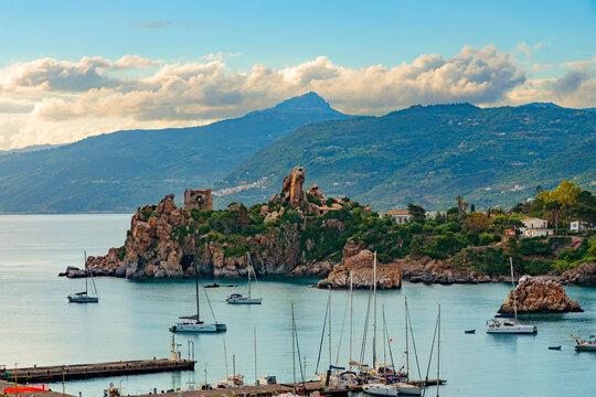 Picturesque Mediterranean bay with sailboats docked near ancient ruins and green hills