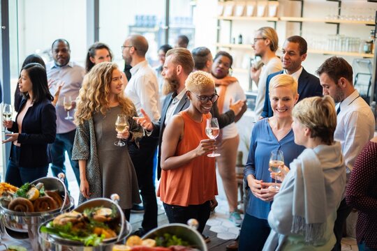 Diverse group of people socializing at a lively indoor gathering.