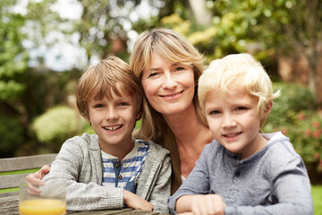 Fototapeta premium Portrait, grandmother and kids in nature with smile, love and bonding together on holiday. Happy, mature woman and children outdoor with embrace, affection and parental support on getaway vacation