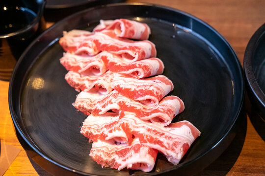 A hotpot meat platter presents thinly sliced beef, pork, and chicken arranged neatly on a serving plate. Close-up compositions emphasize beef marbling, pork color, and the natural fiber patterns of ch