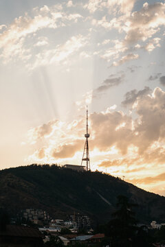 View of Mtatsminda and TV tower against sunset in Tbilisi city landscape