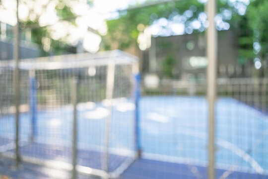 Abstract blurred outdoor futsal court background with a soccer goal post and fences